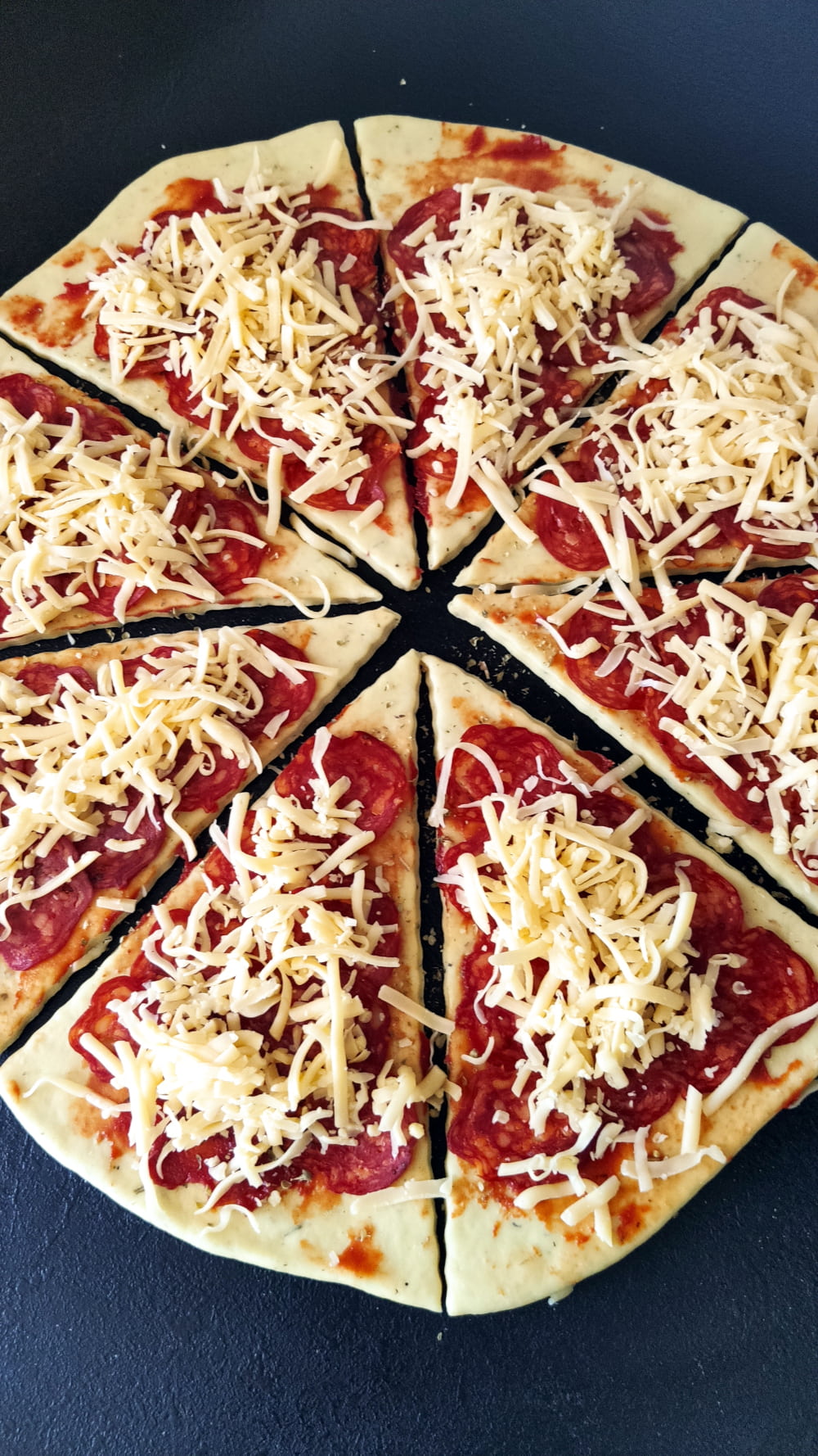 Nadzienie z pepperoni posypane tartym serem cheddar.